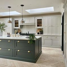 a large kitchen with an island in the middle and lots of cupboards on both sides