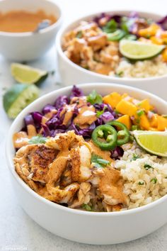 two bowls filled with rice, meat and veggies