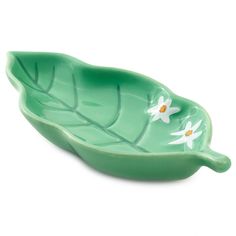 a green leaf shaped bowl with white flowers on it