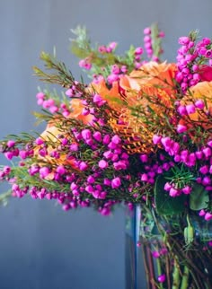 a vase filled with lots of purple and orange flowers