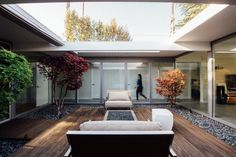 an outdoor living area with wooden floors and white furniture on top of the wood flooring