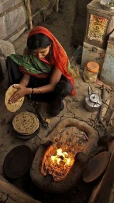 a woman sitting in front of an open fire