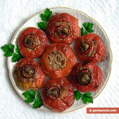 some stuffed tomatoes on a white plate with parsley