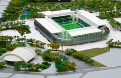 a model of a soccer stadium with trees and bushes surrounding it, including the roof