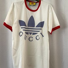 Categories :Women Category:Clothing Sub-Category:T-Shirts Designer:Gucci X Adidas Condition:Nwt Color:White Size:S Gucci Sporty Tops With Letter Print, Sporty Gucci Tops With Letter Print, Sporty Gucci Crew Neck Top, White Sporty Gucci Top, Sporty White Gucci Tops, Designer White Tops With Letter Print, Designer White T-shirt With Logo, Sporty Gucci Tops For Streetwear, Gucci Crew Neck Tops For Streetwear