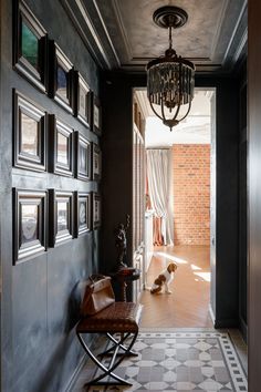 a hallway with pictures on the wall and a dog sitting in the doorway next to it