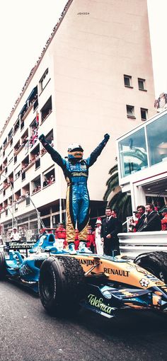 a man standing on top of a race car