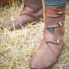 a close up of a person's foot wearing brown boots with braids on them