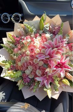 a bouquet of flowers sitting on the dashboard of a car