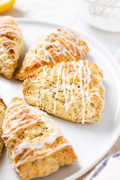 lemon poppy seed scones with icing on a white plate