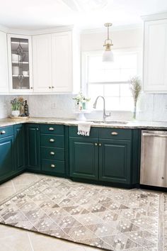 a kitchen with teal cabinets and white walls, an area rug on the floor