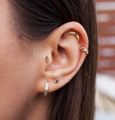 a close up of a person's ear with three different types of piercings