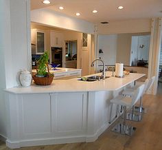 a large kitchen with an island and bar stools next to it in the center of the room