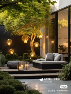 an outdoor living area is lit up with candles and lights in the trees, along with plants