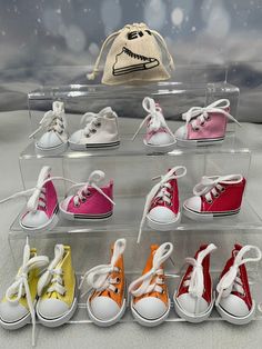 there are many different colored shoes in the display case, and one has a drawstring bag on it