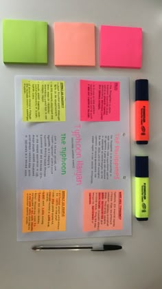 sticky notes and pens on top of a piece of paper