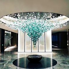 a large chandelier hanging from the ceiling in a room with marble floors and walls