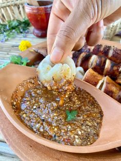 a person dipping some food into a bowl