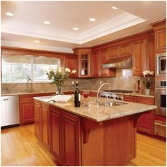 a large kitchen with wooden cabinets and marble counter tops, an island in the middle