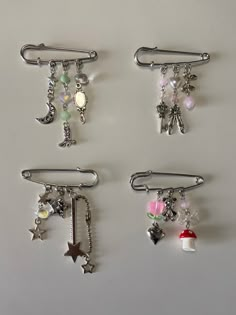 four clips with charms attached to them on a table