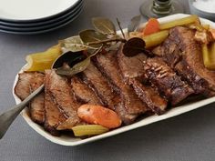 a white plate topped with meat and veggies on top of a gray table