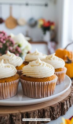 cupcakes with white frosting sitting on a plate