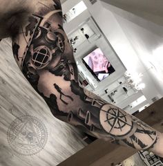 a man's arm with a clock and compass tattoo on it