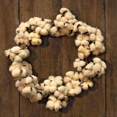 a wreath made out of cotton sitting on top of a wooden wall