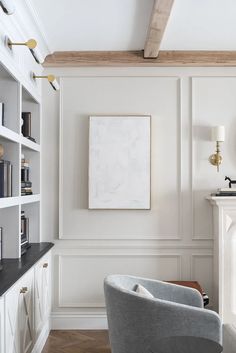 a living room filled with furniture and a painting hanging on the wall above a fireplace