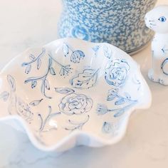 a blue and white bowl with an animal figurine next to it