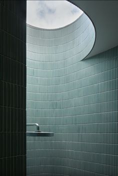 a bathroom with green tiled walls and a skylight