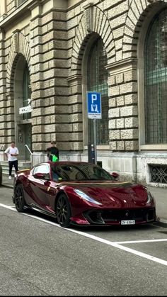 a red sports car is parked on the side of the road in front of a building