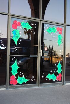 a glass door with christmas decorations on it and stars in the sky behind them,