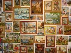 a wall covered in lots of paintings and pictures