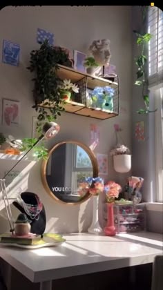 a white desk topped with a mirror next to a window filled with potted plants