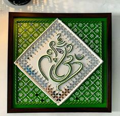 a green and white decorative artwork on a wall