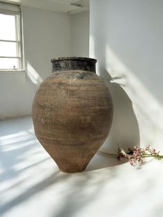 a vase sitting on the floor next to a window