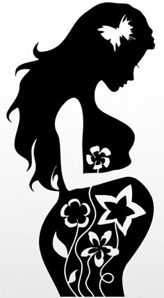 the silhouette of a pregnant woman with flowers in her belly