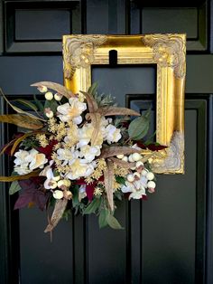 a bouquet of flowers sitting in front of a black door with a gold frame on it