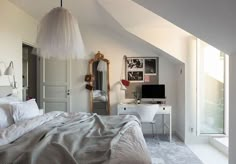 a bedroom with a bed, desk and mirror