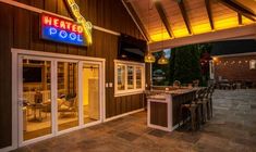 the outside of a restaurant with an outdoor bar and seating area in front of it