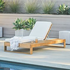 an empty chaise lounge next to a swimming pool