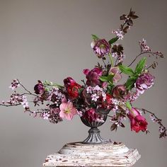 a vase filled with lots of flowers sitting on top of a table