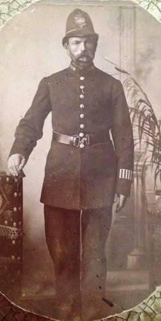 an old photo of a man in uniform holding a suitcase and posing for a picture