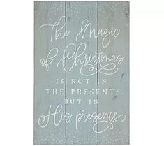 a wooden sign that says the magic of christmas is not in the presents but in his presence