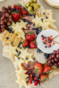 a platter filled with cheese, fruit and crackers