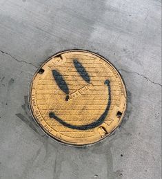 a manhole cover with a smiley face drawn on it