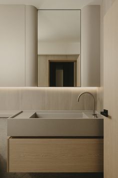 a bathroom sink sitting under a large mirror next to a wooden cabinet and counter top