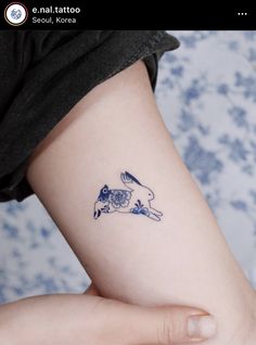 a small tattoo on the arm of a woman's left arm, depicting a rabbit