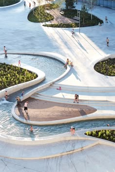 an aerial view of people playing in the water at a park with ramps and fountains